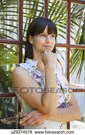 Stock Photo - Woman with clippers standing by window. Fotosearch