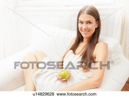 Woman wrapped in towel eating apple View Large Photo Image Stock Photo - Woman wrapped in towel eating apple. Fotosearch