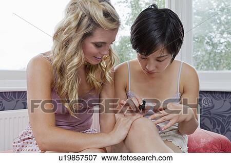 Stock Photo - Women painting each other's nails. Fotosearch