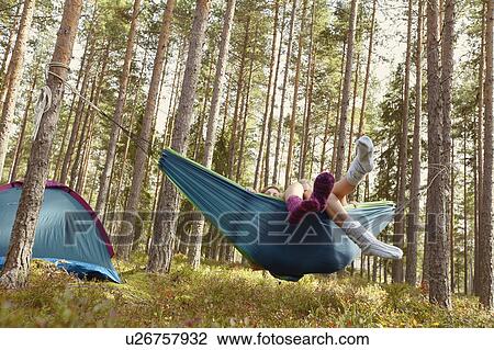 Women relaxing in hammock at campsite View Large Photo Image Stock Image - Women relaxing in hammock at campsite. Fotosearch