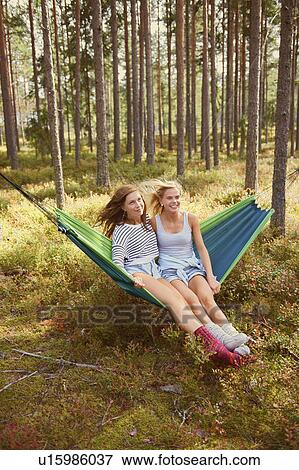 Women relaxing in hammock in forest View Large Photo Image Stock Photo - Women relaxing in hammock in forest. Fotosearch