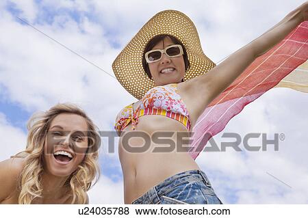 Stock Photo - Women standing with arms outstretched. Fotosearch