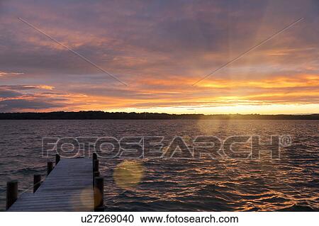 Wooden dock reaching out into lake View Large Photo Image Stock Image - Wooden dock reaching out into lake. Fotosearch