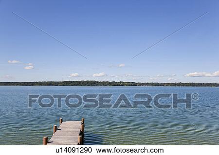Wooden dock stretching into still lake View Large Photo Image Stock Image - Wooden dock stretching into still lake. Fotosearch