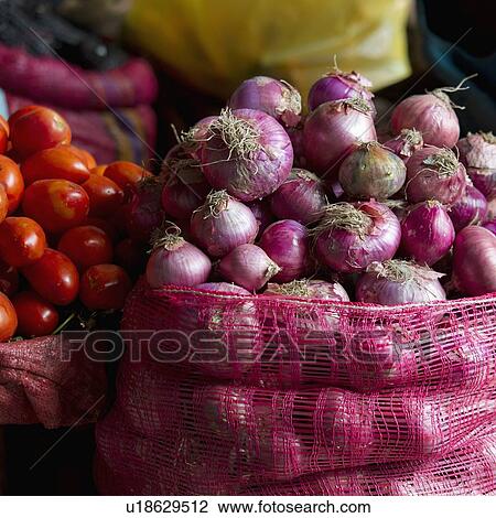 Stock Image - Mesh Bags Full Of Onions Tomatoes And Other Vegetables; Cusco Peru. Fotosearch