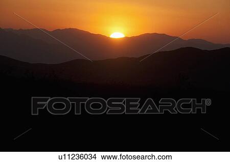 Sunset Over The Mountains Of The Mojave Desert National Preserve; Baker, California, United States Of America View Large Photo Image Picture - Sunset Over The Mountains Of The Mojave Desert National Preserve; Baker, California, United States Of America. Fotosearch