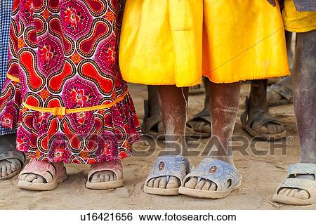 Close up detail of Masai children's feet, all wearing dusty sandals, and brightly coloured clothing, Amboseli, Kenya, East Africa View Large Photo Image Stock Photograph - Close up detail of Masai children's feet, all wearing dusty sandals, and brightly coloured clothing, Amboseli, Kenya, East Africa. Fotosearch