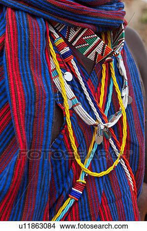 Picture - Close up detail of Masai warrior chest with blue and red striped shuka and muchbeaded jewellery, Amboseli, Kenya, East Africa. Fotosearch