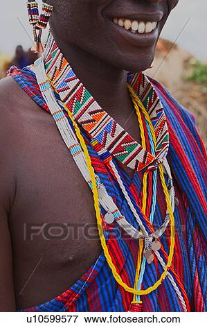 Stock Photo - Close up detail of Masai warrior chest and lower face, with blue and red striped shuka and muchbeaded jewellery, Amboseli, Kenya, East Africa. Fotosearch