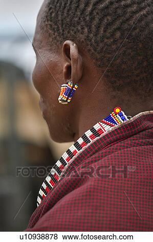 Stock Photo - Close up side view of Masai warrior, wearing traditional red shuka and beaded jewellery, Amboseli, Kenya, East Africa. Fotosearch