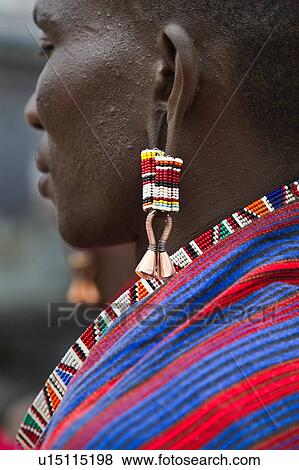 Stock Photo - Close up side view of Masai warrior, wearing traditional red and blue shuka and beaded jewellery, Amboseli, Kenya, East Africa. Fotosearch