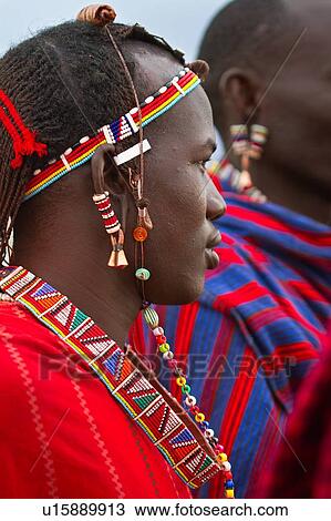 Close up side view of young Masai warrior (moran), with long braided hair, wearing traditional red shuka and beaded jewellery, Amboseli, Kenya, East Africa View Large Photo Image Stock Image - Close up side view of young Masai warrior (moran), with long braided hair, wearing traditional red shuka and beaded jewellery, Amboseli, Kenya, East Africa. Fotosearch