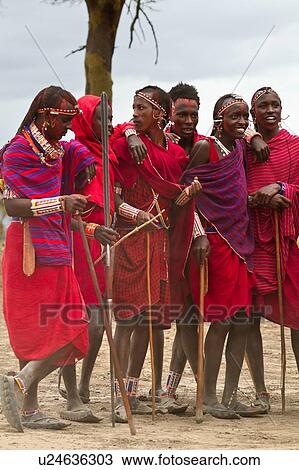 Stock Image - Masai aduma: close up of group of young Masai warriors standing during dancing, all holding traditional sticks, Amboseli, Kenya, East Africa. Fotosearch
