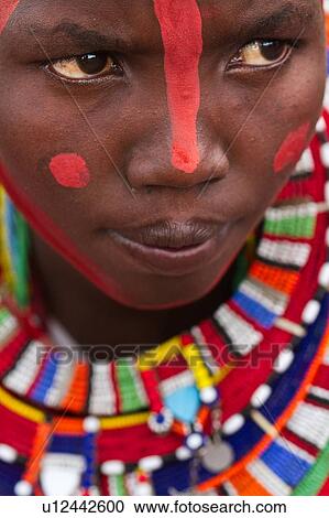 Masai applying paints for celebrations: young woman with much beaded jewellery sits after red paint has been applied to her face, close up detail of face, Amboseli, Kenya, East Africa View Large Photo Image Stock Image - Masai applying paints for celebrations: young woman with much beaded jewellery sits after red paint has been applied to her face, close up detail of face, Amboseli, Kenya, East Africa. Fotosearch