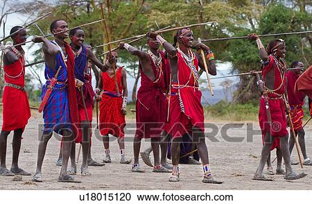 Masai Olympics: group of nearly twenty Masai warriors, all dressed in traditional red and blue shukas, stand in line for spear throwing competition, Amboseli, Kenya, East Africa View Large Photo Image Stock Image - Masai Olympics: group of nearly twenty Masai warriors, all dressed in traditional red and blue shukas, stand in line for spear throwing competition, Amboseli, Kenya, East Africa. Fotosearch