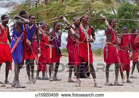 Stock Photo - Masai Olympics: group of nearly twenty Masai warriors, all dressed in traditional red and blue shukas, stand in line for spear throwing competition, Amboseli, Kenya, East Africa. Fotosearch