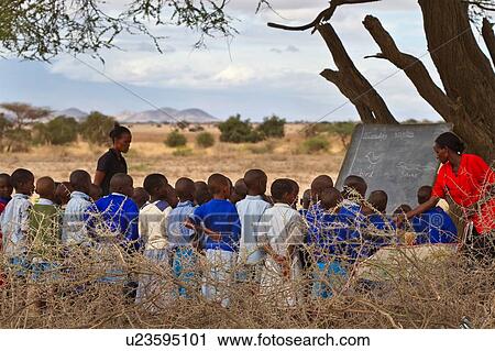 Masai school out on the plains: as seen from the back, a group of children stand in the acacia thorn enclosure in front of a blackboard under a tree, while the teacher, dressed in a bright red dress, teaches them English, with an assistant standing nearby View Large Photo Image Stock Image - Masai school out on the plains: as seen from the back, a group of children stand in the acacia thorn enclosure in front of a blackboard under a tree, while the teacher, dressed in a bright red dress, teaches them English, with an assistant standing nearby. Fotosearch