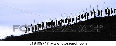 Masai silhouettes: over thirty Masai warriors stand at top of hill in early evening, holding traditional sticks, outlined against bright sky, Amboseli, Kenya, East Africa View Large Photo Image Stock Photo - Masai silhouettes: over thirty Masai warriors stand at top of hill in early evening, holding traditional sticks, outlined against bright sky, Amboseli, Kenya, East Africa. Fotosearch