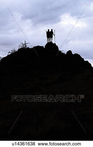 Masai silhouettes: two warriors stand at top of hill in early evening, holding traditional sticks, outlined against bright sky, Amboseli, Kenya, East Africa View Large Photo Image Stock Photo - Masai silhouettes: two warriors stand at top of hill in early evening, holding traditional sticks, outlined against bright sky, Amboseli, Kenya, East Africa. Fotosearch