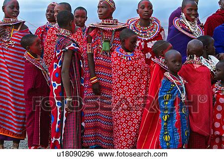 Masai women stand in golden evening sunlight, dressed in colourful red and white wraps, with much beaded jewellery, and painted faces for celebrations, close up from below, Amboseli, Kenya, East Africa View Large Photo Image Stock Photograph - Masai women stand in golden evening sunlight, dressed in colourful red and white wraps, with much beaded jewellery, and painted faces for celebrations, close up from below, Amboseli, Kenya, East Africa. Fotosearch