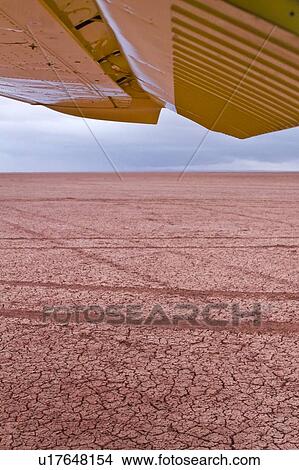 View under wing from open yellow Cessna plane over dry lake bed, Amboseli, Kenya, East Africa View Large Photo Image Picture - View under wing from open yellow Cessna plane over dry lake bed, Amboseli, Kenya, East Africa. Fotosearch