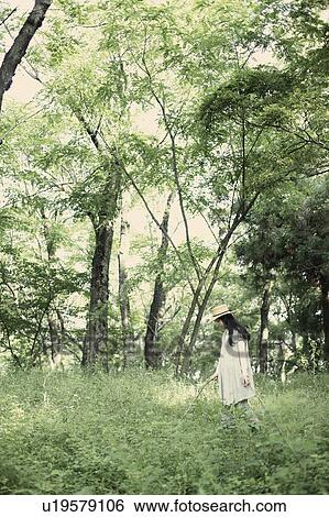 Stock Photograph - A young woman in the forest. Fotosearch
