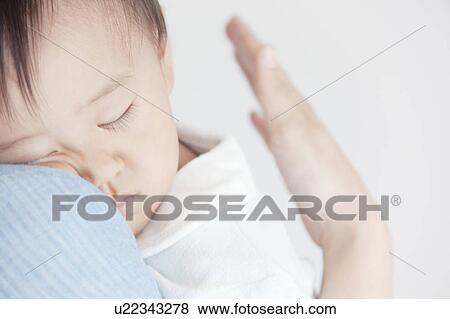 Stock Photo - Baby Sleeping on Mother's Shoulder. Fotosearch