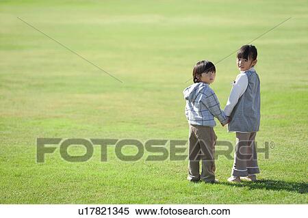 Stock Photography - Boy and Girl Holding Hands in Field. Fotosearch