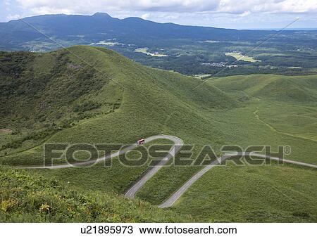 Stock Image - Bus Running on Winding Road. Fotosearch