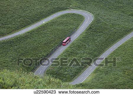 Stock Image - Bus Running on Winding Road. Fotosearch