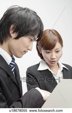 Stock Photography - Businessman and Businesswoman Looking at File. Fotosearch