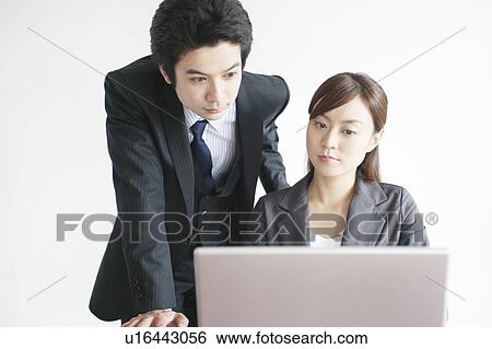 Stock Photograph - Businessman and Businesswoman Using Laptop. Fotosearch