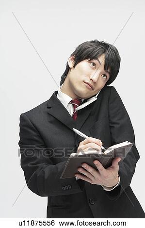 Businessman On The Phone and Making Notes View Large Photo Image Stock Photograph - Businessman On The Phone and Making Notes. Fotosearch