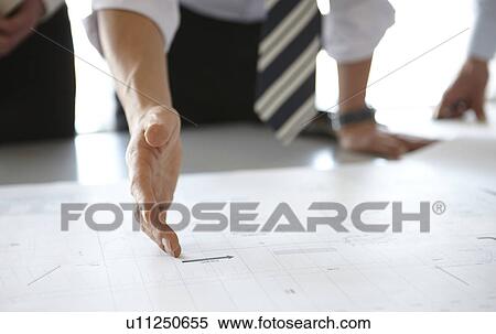 Stock Photography - Businessman Ponting at Blueprint. Fotosearch