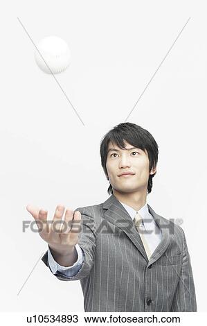 Stock Image - Businessman Tossing Baseball Ball in Air. Fotosearch