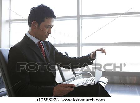 Businessman Using Laptop at Airport View Large Photo Image Stock Image - Businessman Using Laptop at Airport. Fotosearch
