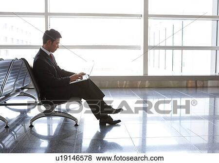 Businessman Using Laptop at Airport View Large Photo Image Stock Photo - Businessman Using Laptop at Airport. Fotosearch
