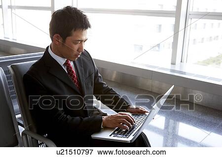 Stock Photo - Businessman Using Laptop at Airport. Fotosearch