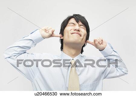 Stock Image - Businessman with Fingers in Ears. Fotosearch