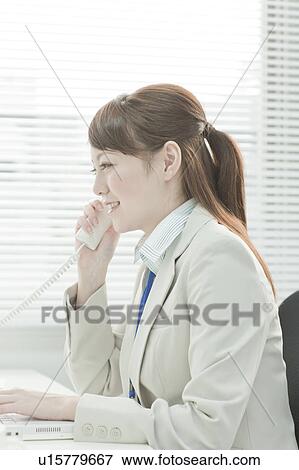 Businessman Woman Using Laptop and Talking on Phone View Large Photo Image Stock Photo - Businessman Woman Using Laptop and Talking on Phone. Fotosearch