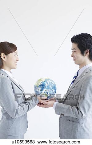 Stock Photo - Businesspeople Holding Globe. Fotosearch
