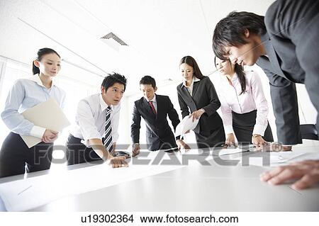 Picture - Businesspeople Looking at Documents in Meeting. Fotosearch