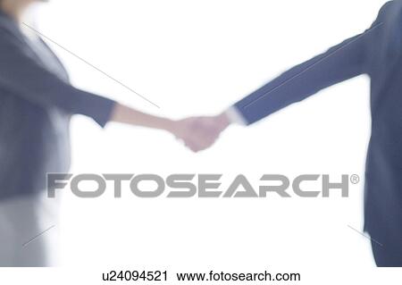 Stock Image - Businesswoman and Businessman Shaking Hands. Fotosearch