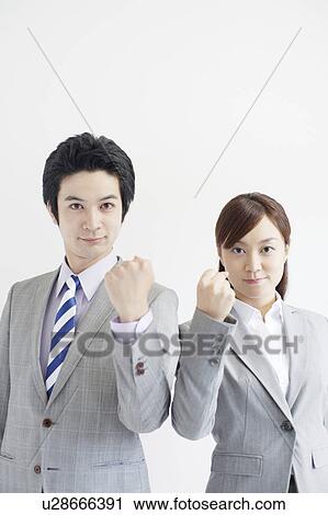 Stock Image - Businesswoman and Businessman with Firsts Raised. Fotosearch