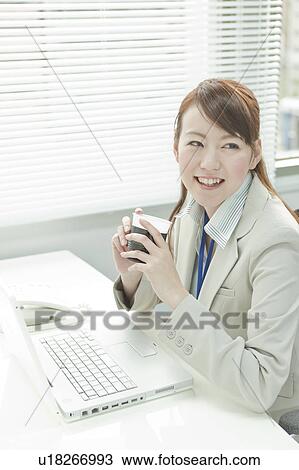 Stock Image - Businesswoman Having Coffee Break. Fotosearch