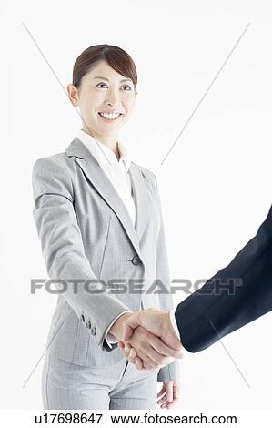 Stock Photo - Businesswoman Shaking Hands With Colleague. Fotosearch