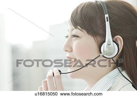 Stock Image - Businesswoman Using Headset. Fotosearch