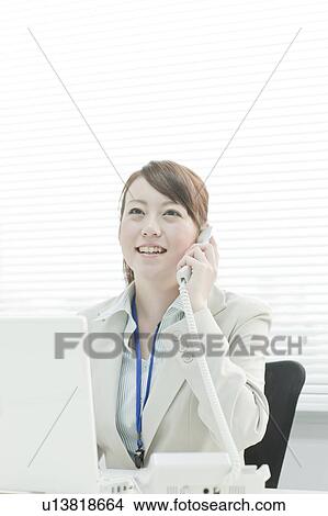 Businesswoman Using Laptop and Talking on Phone View Large Photo Image Picture - Businesswoman Using Laptop and Talking on Phone. Fotosearch