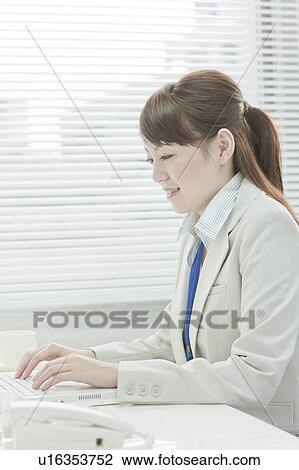 Stock Image - Businesswoman Using Laptop. Fotosearch