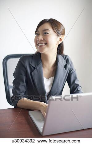 Stock Image - Businesswoman Using Laptop. Fotosearch